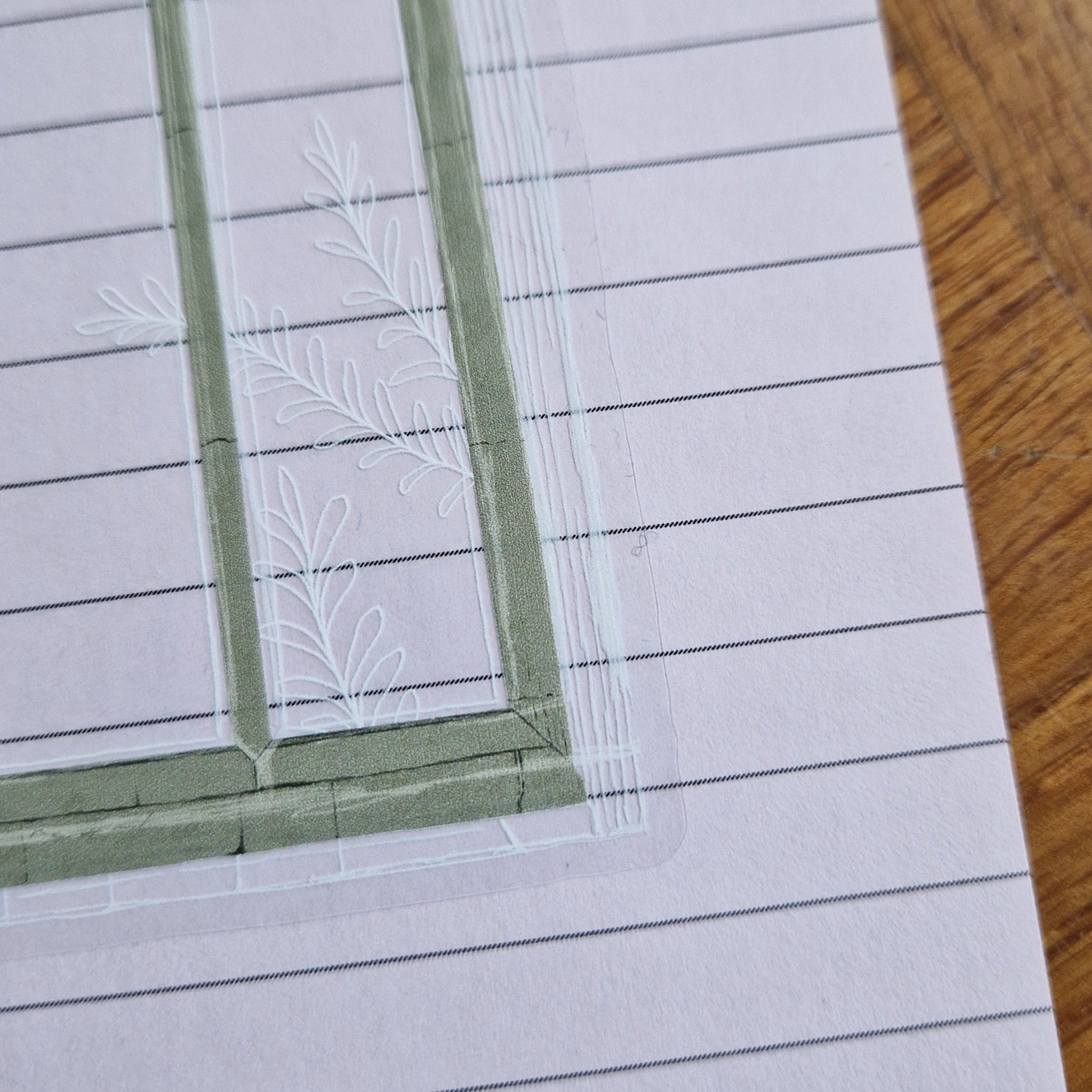 A close up of the bottom right of the transparent backgrounded cathedral window sticker showing the grey texture stone and the leafy vine illustration going across the window.