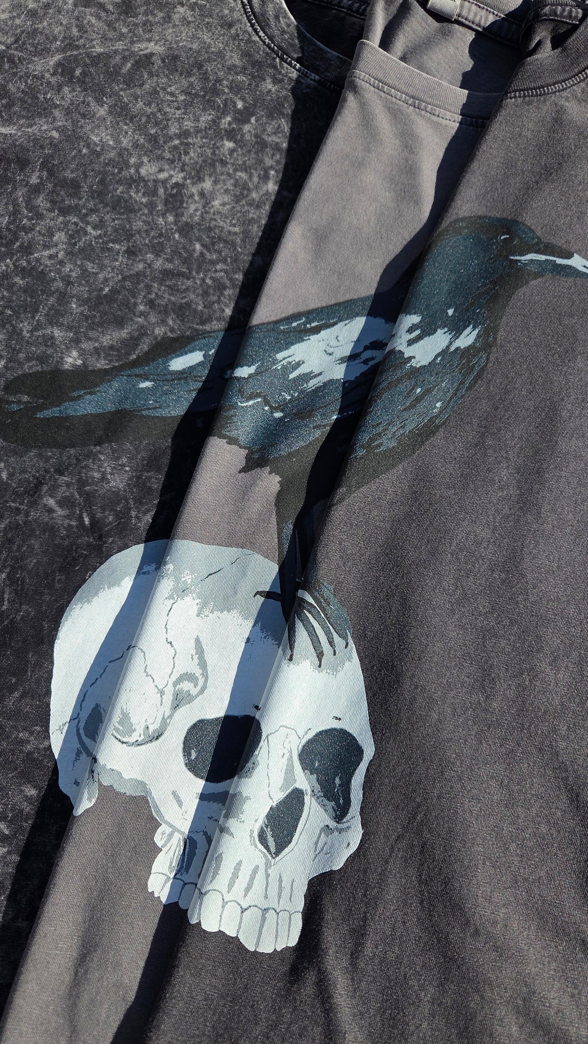 A close up of the three shirts showing the difference in shirt colours, focusing on the crow and skull design.