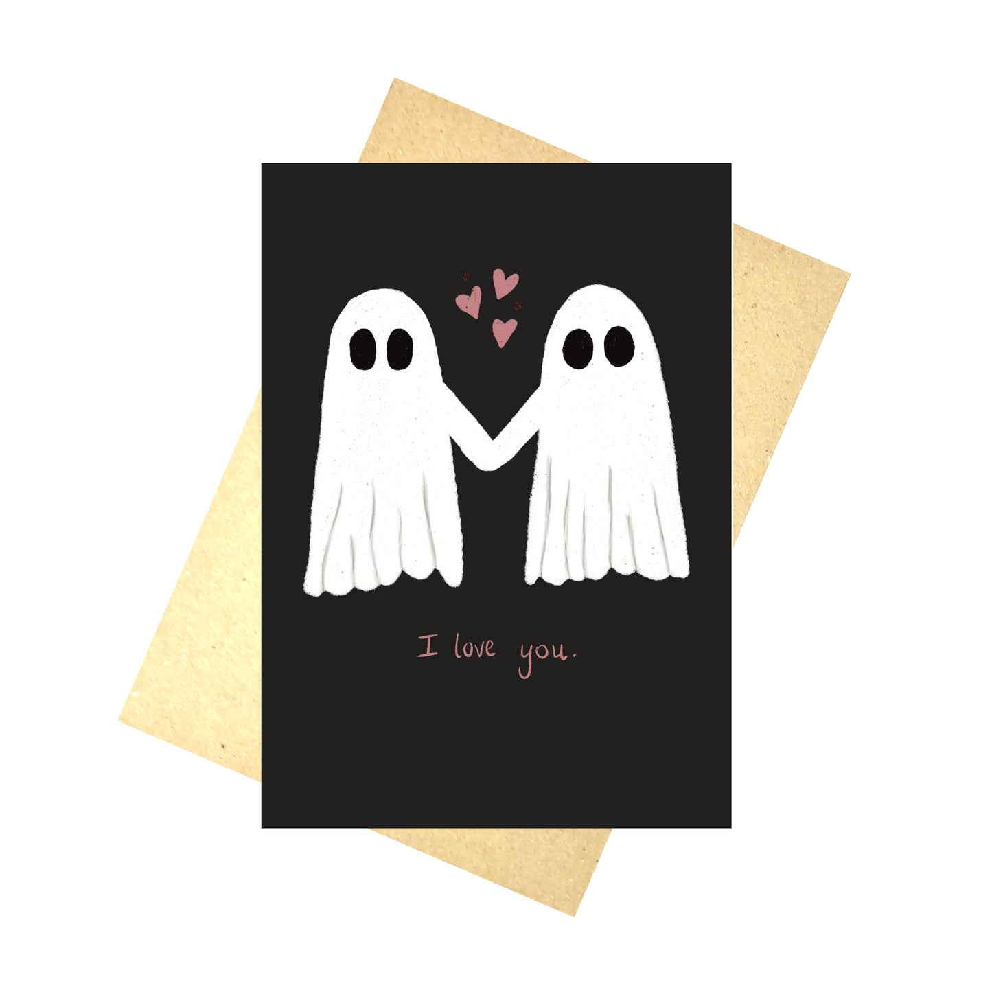 A black card with two ghosts holding hands with pink hearts in the air between them. Under the ghosts are the words 'I love you.' in pink handwriting. Behind the card is a brown envelope and a white background.