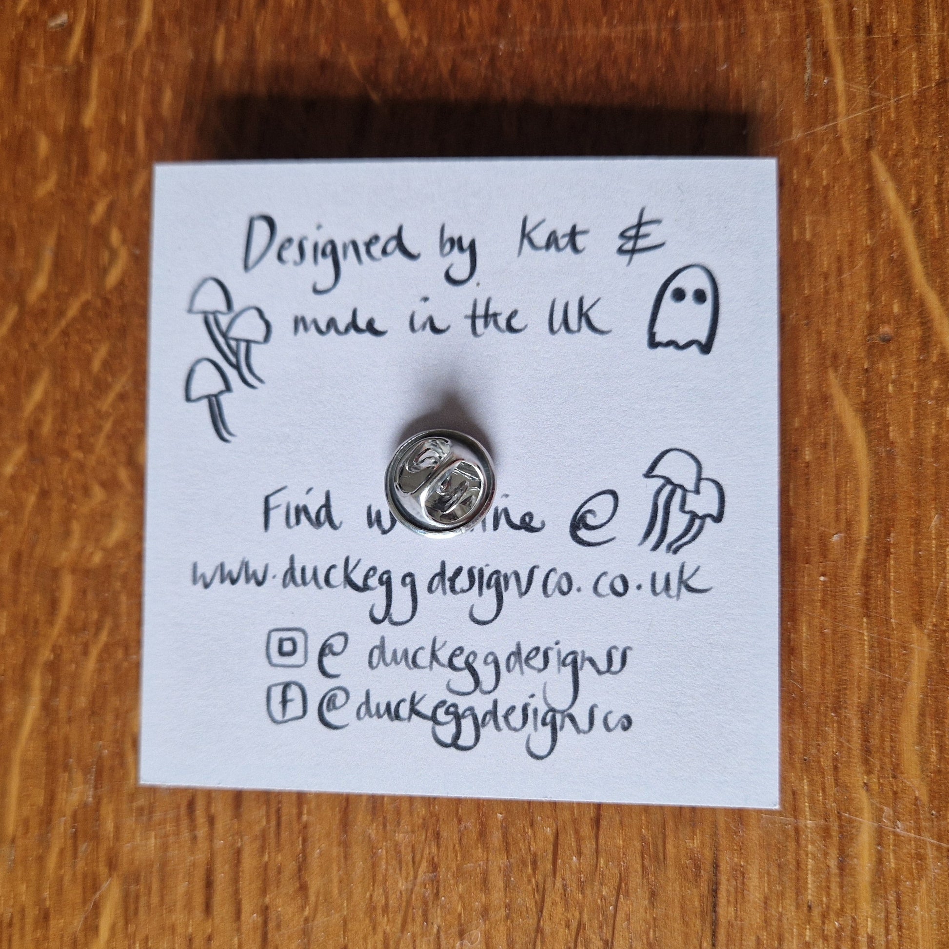 The back of the pin badge backing card showing the silver metal butterfly clutch back of the pin.