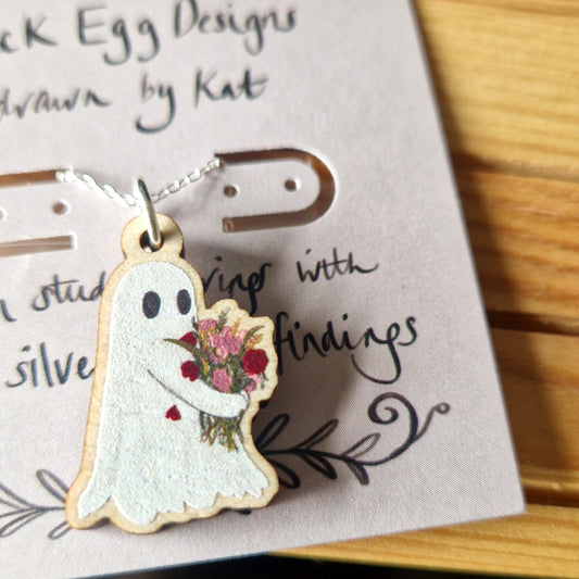 Ghost-shaped pendant with floral design on a card with 'Duck Egg Designs' text