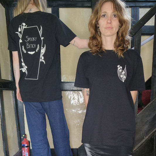 Two people wearing black t-shirts with designs on a staircase. Showing the front and back of the tshirt.