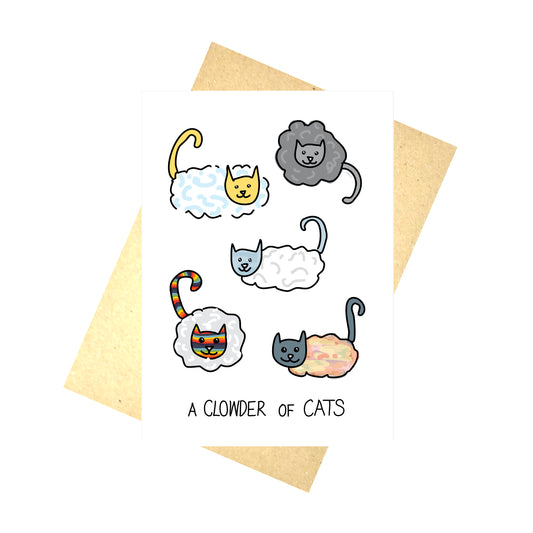 White card with cats that are part cloud with regular heads and tails with a cloud body. The cats are a variety of different colours inspired by the weather and the sky. At the bottom of the card are the words 'A CLOWDER OF CATS' in black handwriting. Behind the card is a brown envelope at an angle, behind which is a white background.