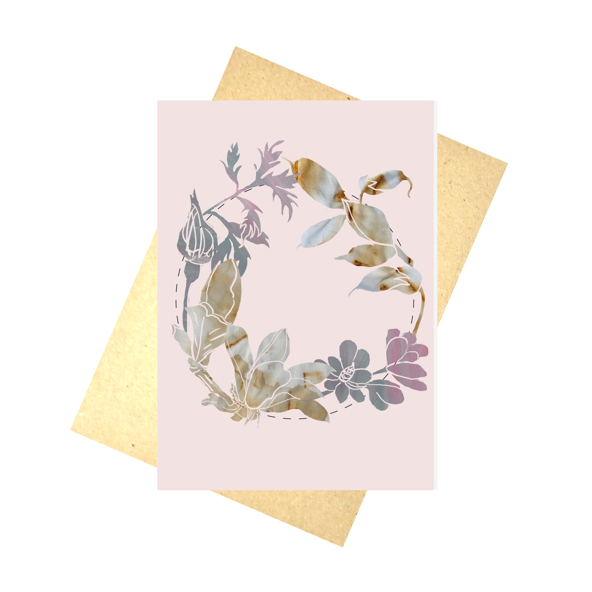 A pale pink card featuring a silhouette wreath made using photos of naturally dyed fabric and a painted background. The wreath is central to the card and features a dashed line circle behind the flowers. Behind the card is a brown envelope, behind which is a white background.